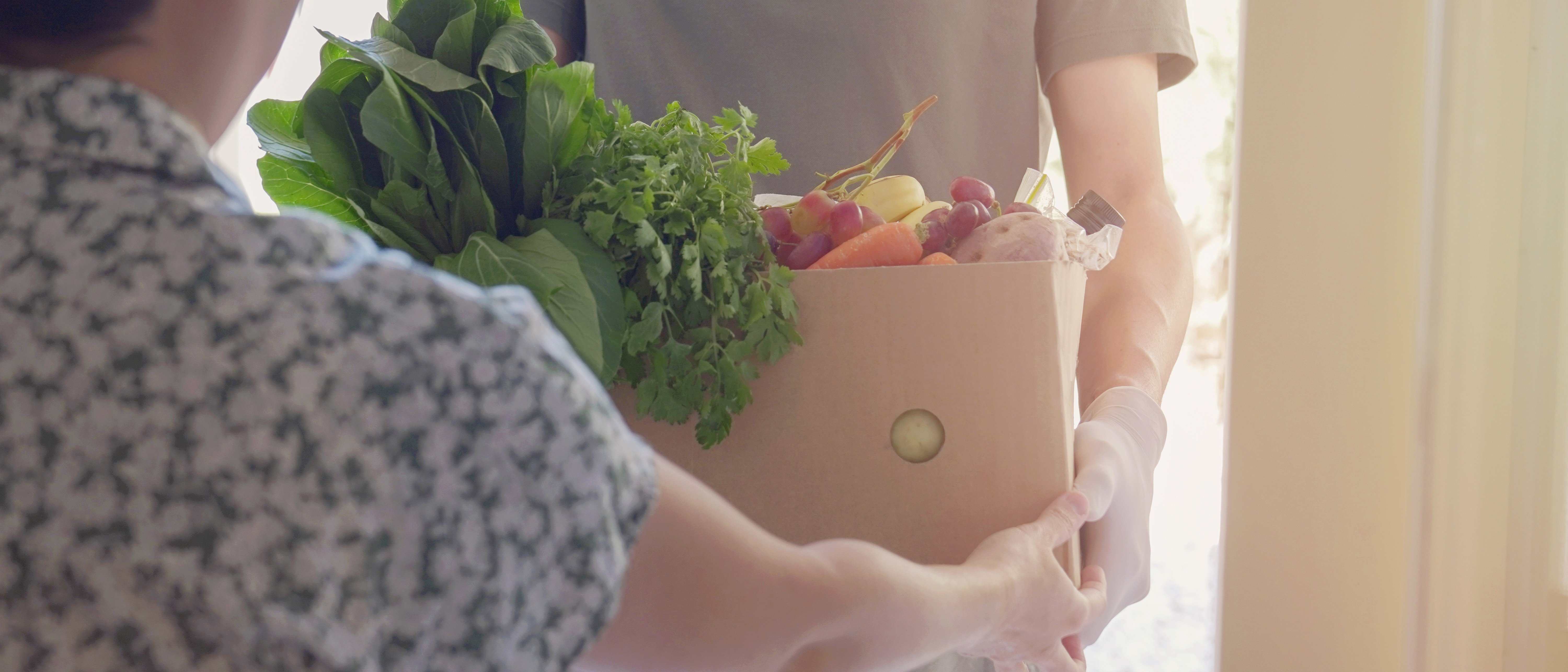 Volunteer giving local family box of food